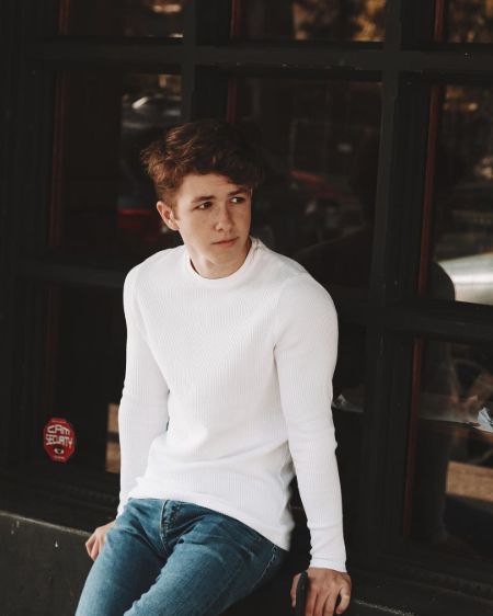 Ethan Wacker in a white t-shirt poses for a photoshoot.